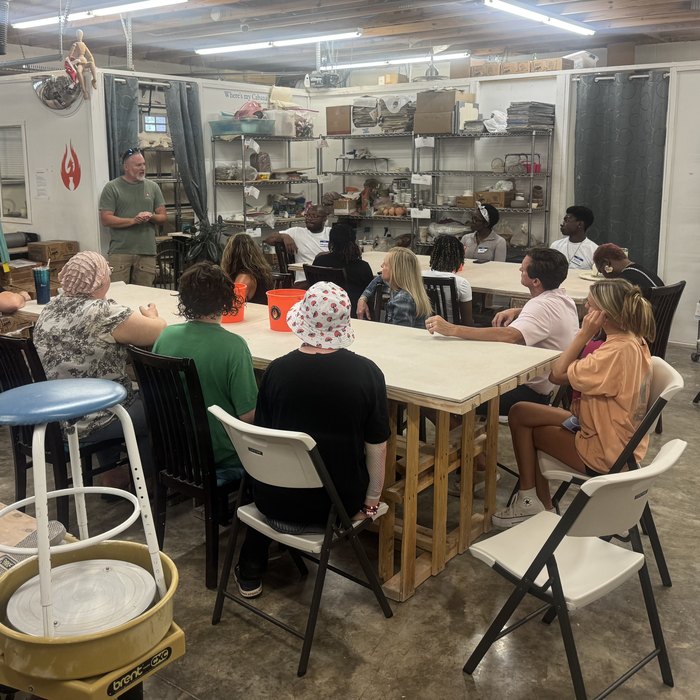 Families taking part in a hands-on pottery workshop